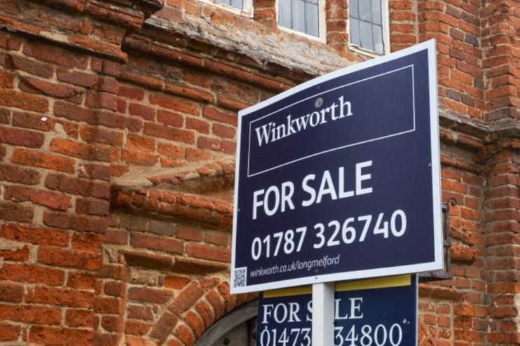Winkworth estate agent For Sale sign in front of a brick building, indicating property prices and availability.