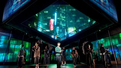 Xander Pang Light and the cast of Death Note The Musical on stage with Tokyo cityscape projections