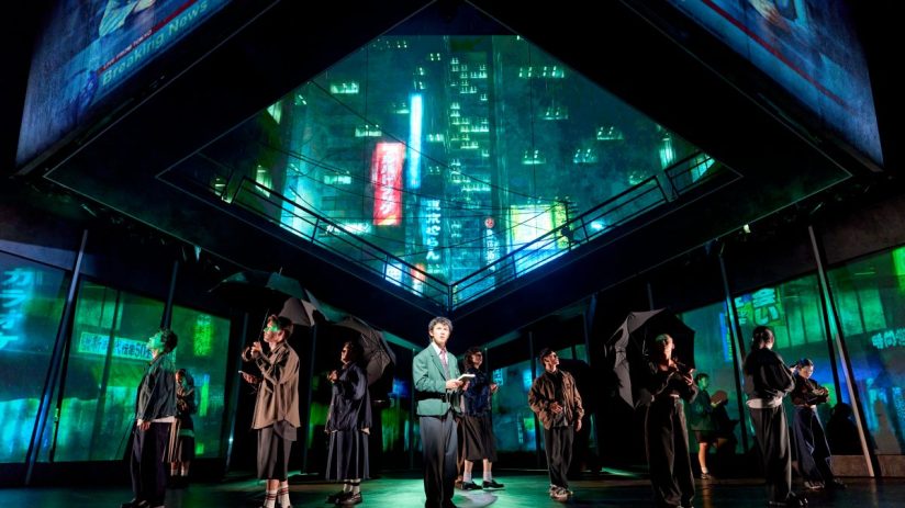 Xander Pang Light and the cast of Death Note The Musical on stage with Tokyo cityscape projections