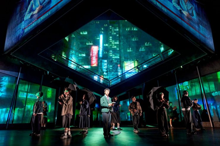 Xander Pang Light and the cast of Death Note The Musical on stage with Tokyo cityscape projections