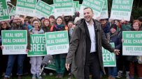 Zach Polanski at a Green Party rally with supporters holding Vote Green signs