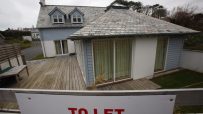 Holiday let house with slate roof, dormer windows, and a TO LET sign in the foreground.