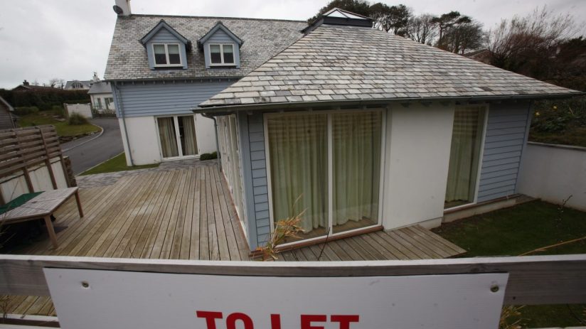Holiday let house with slate roof, dormer windows, and a TO LET sign in the foreground.