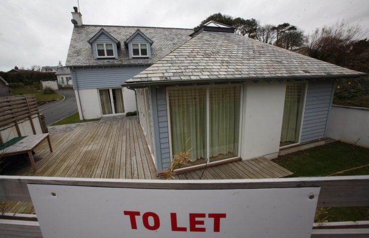Holiday let house with slate roof, dormer windows, and a TO LET sign in the foreground.