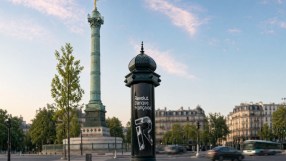 Revolut Banque Fran&ccedil;aise ad on a Morris column in Paris, with the July Column and blurred traffic in the background.