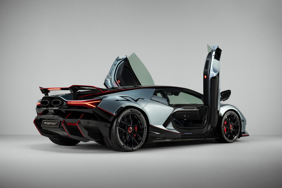 Sleek grey and black Lamborghini Revuelto SV with red accents, rear view, and scissor doors open, showcasing design.