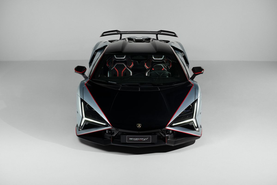 Front view of a sleek, futuristic silver and black sports car with red accents and LED headlights.