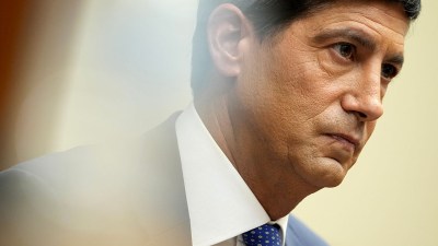 Kevin Warsh, former Fed Governor, in a suit and blue tie, attending Jackson Hole meeting.