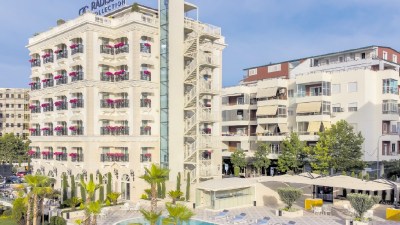 Radisson Collection hotel in Tirana, Albania, featuring a swimming pool, palm trees, and an external fire escape.