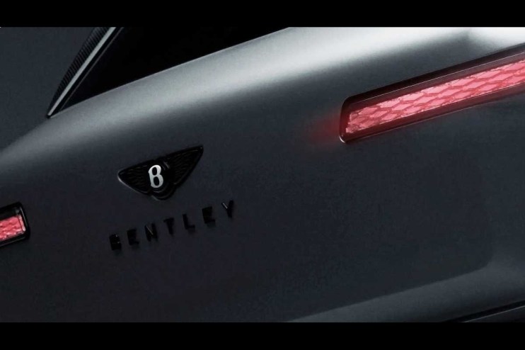 Close-up of a matte dark grey Bentley car with a B logo and red taillights