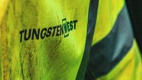 Tungsten West logo on a neon yellow high-visibility jacket with reflective stripes, suggesting mining or industrial work.