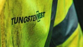 Tungsten West logo on a neon yellow high-visibility jacket with reflective stripes, suggesting mining or industrial work.