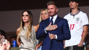 David Beckham in a navy suit with hand on chest, Victoria Beckham in sunglasses, and Brooklyn Beckham in an England jersey.