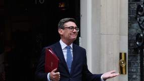 Andy Burnham, Mayor of Greater Manchester, in a dark suit holding a red folder outside 10 Downing Street
