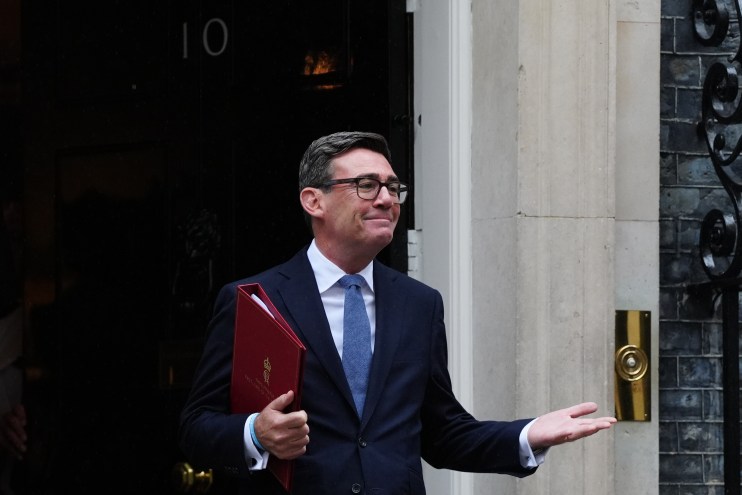 Andy Burnham, Mayor of Greater Manchester, in a dark suit holding a red folder outside 10 Downing Street