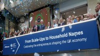 Confetti falls on a group of business professionals at the London Stock Exchange, celebrating UK entrepreneurs.
