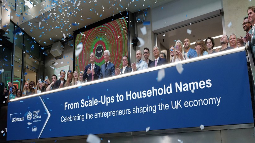 Confetti falls on a group of business professionals at the London Stock Exchange, celebrating UK entrepreneurs.