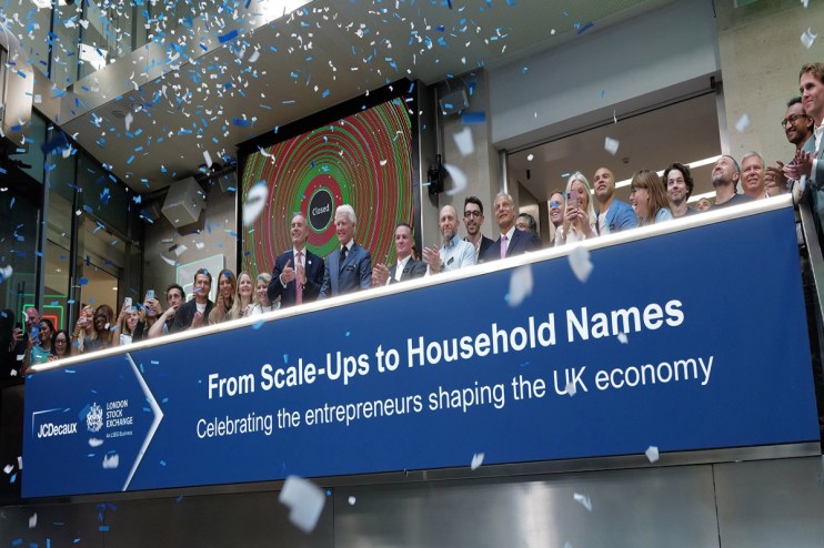 Confetti falls on a group of business professionals at the London Stock Exchange, celebrating UK entrepreneurs.