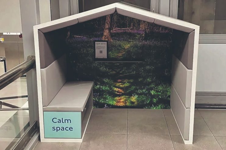 Calm Space booth with a nature mural and light grey bench, offering a quiet retreat in a public area.
