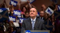Alex Salmond speaks at a podium with Yes in Your Hands slogan, supporters holding Yes signs in background.