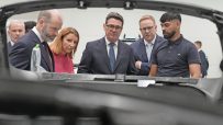 Andy Burnham and others inspecting a manufacturing process, likely at a Labour Party conference related event.