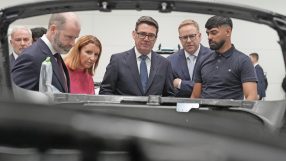 Andy Burnham and others inspecting a manufacturing process, likely at a Labour Party conference related event.