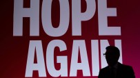 Silhouette of Andy Burnham speaking, with HOPE AGAIN text in white on a red background behind him.