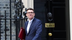 Andy Burnham leaves 10 Downing Street, holding a red folder, in a navy suit and white tie