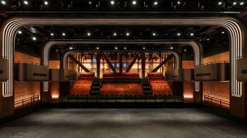 Interior of a modern music venue in London with a stage, tiered seating, and architectural lighting.