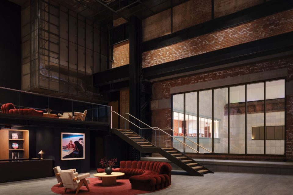 Luxurious Apple music venue interior with red velvet seating, modern staircase, exposed brick, and large windows