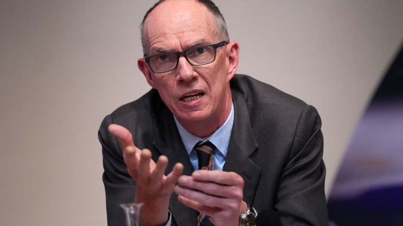 Bank of England Deputy Governor Dave Ramsden speaking, gesturing with hands, wearing glasses and a suit.