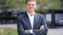 Bjorn Sibbern, Six Exchange executive, in a dark suit with arms crossed, smiling outdoors.