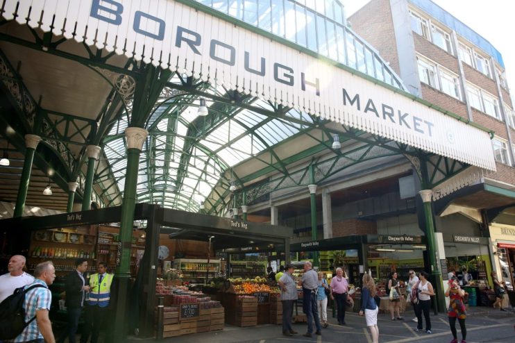 Borough Market entrance with vendors, fresh produce, and shoppers under the iconic green roof structure