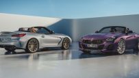 Silver and purple BMW Z4 convertible sportscars with custom wheels on a light grey floor.