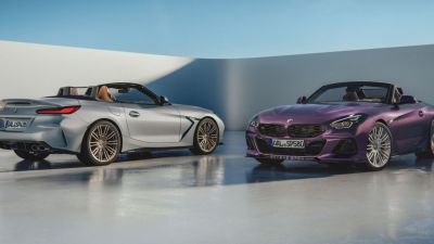Silver and purple BMW Z4 convertible sportscars with custom wheels on a light grey floor.