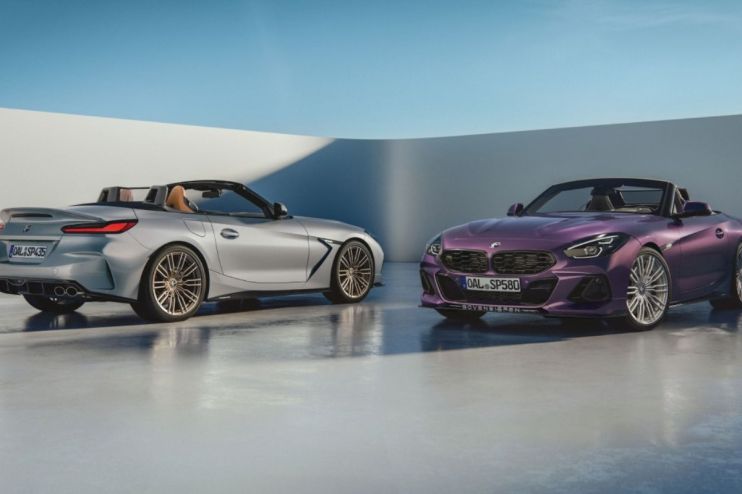 Silver and purple BMW Z4 convertible sportscars with custom wheels on a light grey floor.