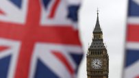Big Ben clock tower with the British Union Jack flag blurred in the foreground, representing UK parliament
