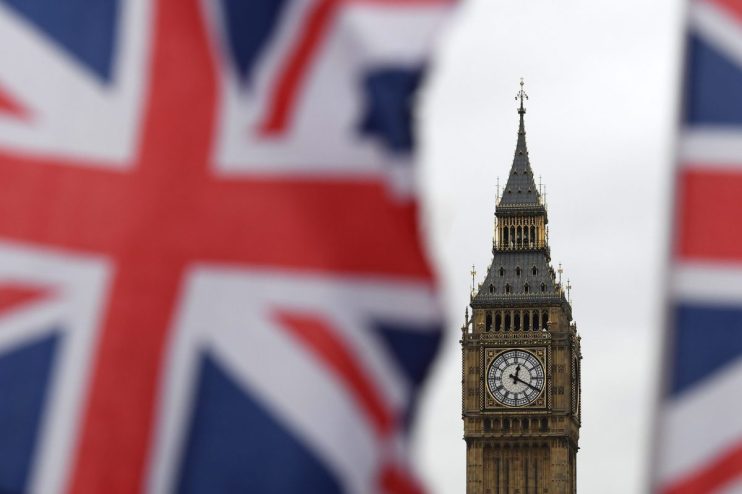 Big Ben clock tower with the British Union Jack flag blurred in the foreground, representing UK parliament