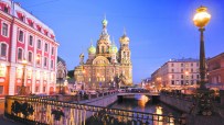 Church of the Savior on Spilled Blood in St. Petersburg at dusk, golden domes and intricate facades illuminated