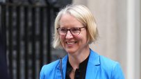 Emma Reynolds, a blonde woman in glasses and blue blazer, smiling outdoors