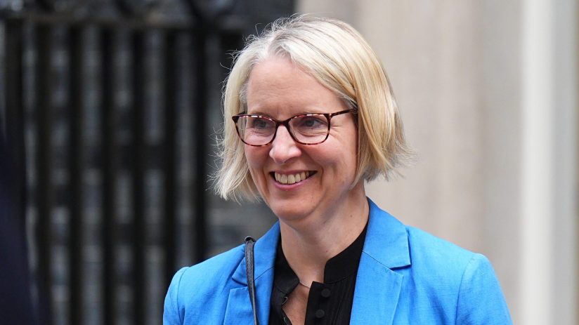 Emma Reynolds, a blonde woman in glasses and blue blazer, smiling outdoors