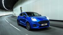 Blue Ford Puma SUV driving through a modern tunnel, motion blur on the road