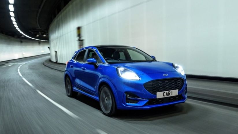 Blue Ford Puma SUV driving through a modern tunnel, motion blur on the road