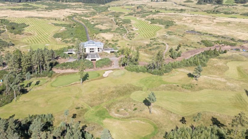 Aerial view of GWest Resort Perthshire golf course with clubhouse, green fairways, and surrounding woodland