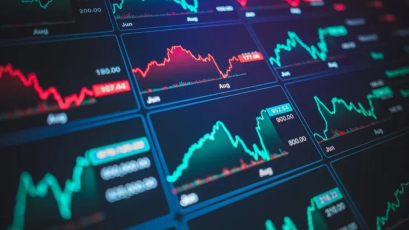 Digital display of stock market charts with fluctuating red and green lines, indicating financial data and trends
