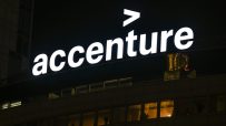 Accenture logo illuminated at night on a corporate building, showcasing the companys branding.