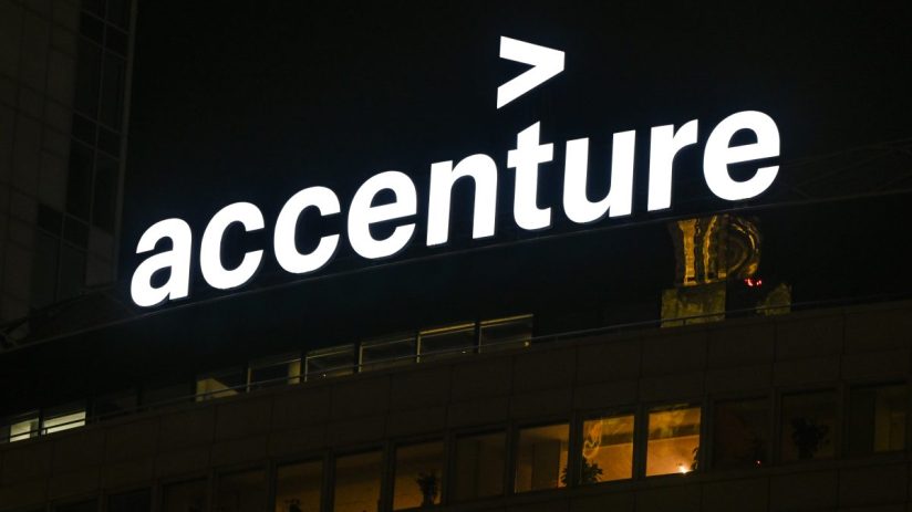 Accenture logo illuminated at night on a corporate building, showcasing the companys branding.