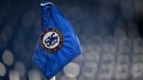 Close-up of a blue Chelsea Football Club corner flag with visible raindrops and the club crest.