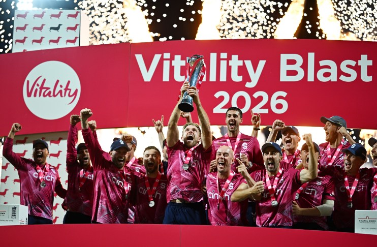 Cricket team in pink jerseys celebrating a Vitality Blast 2026 championship win, holding up the trophy with fireworks.