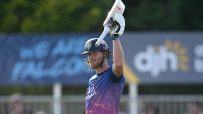 Ben Stokes, in batting gear, raises his cricket bat in celebration on the field.